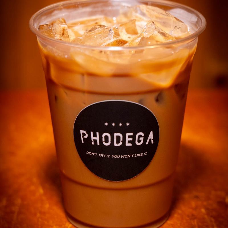 Iced coffee with milk in a clear cup labeled "PHODEGA