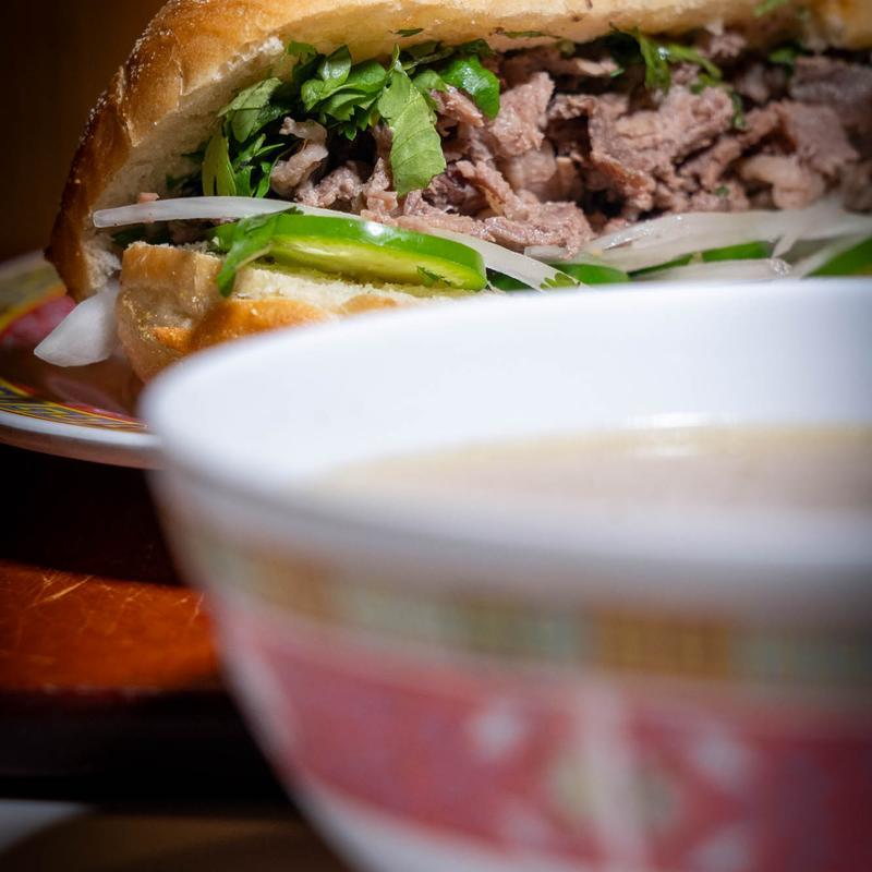 Banh mi sandwich with sliced beef, cucumber, onion, and cilantro