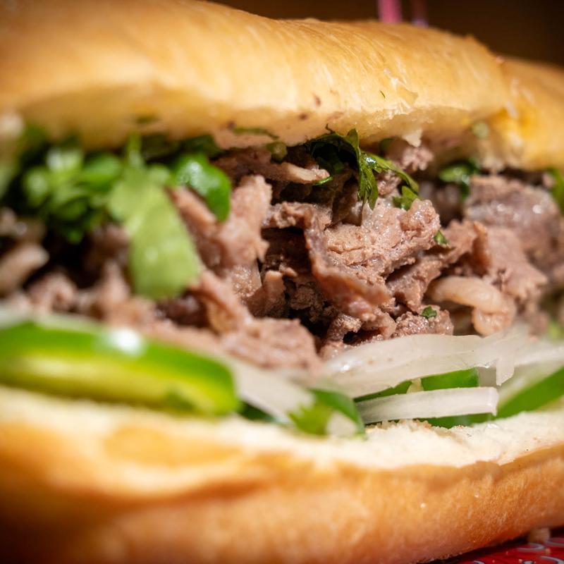 Vietnamese banh mi with shredded beef, cilantro, jalapeño, and pickled onion
